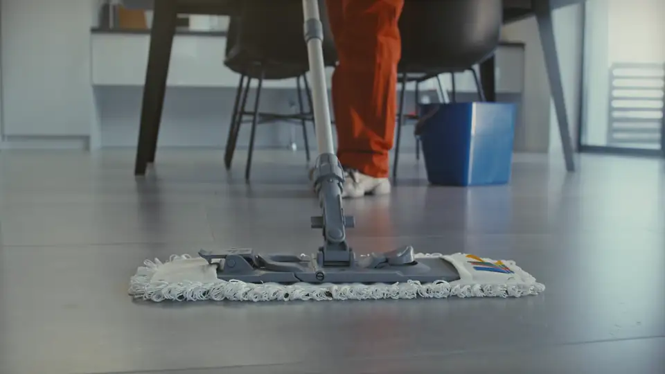 A flat mop sweeping across a polished floor